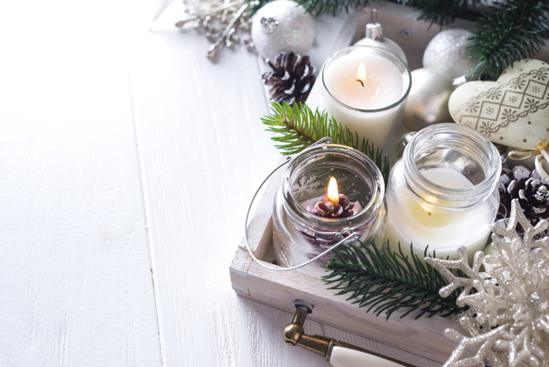 Рождественская открытка с светящимися маленькими свечами и еловыми конусами
 - Фото, изображение
