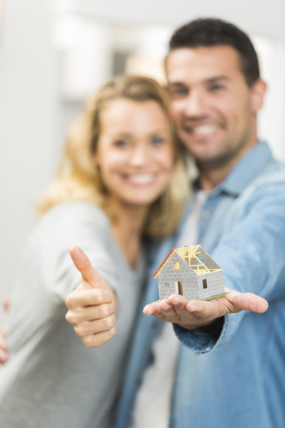 Happy young couple with the model of their future house - Foto, Imagen