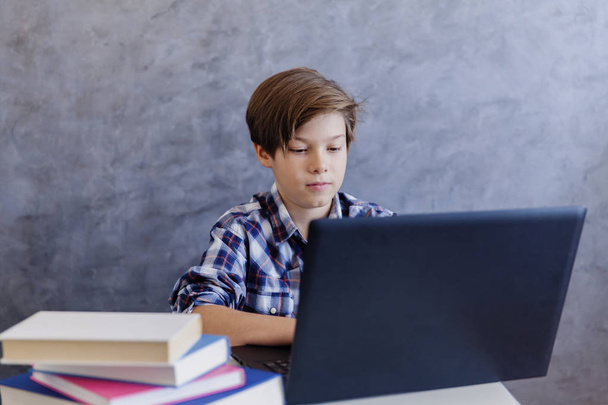 Roztomilý dospívající mládež chlapec pracoval na notebooku doma - Fotografie, Obrázek