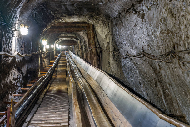 Riem conveyot in verlichte ondergrondse tunnel - Foto, afbeelding