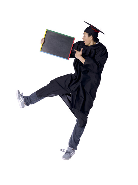 male graduate jumping while pointing on his blackboard - Photo, Image