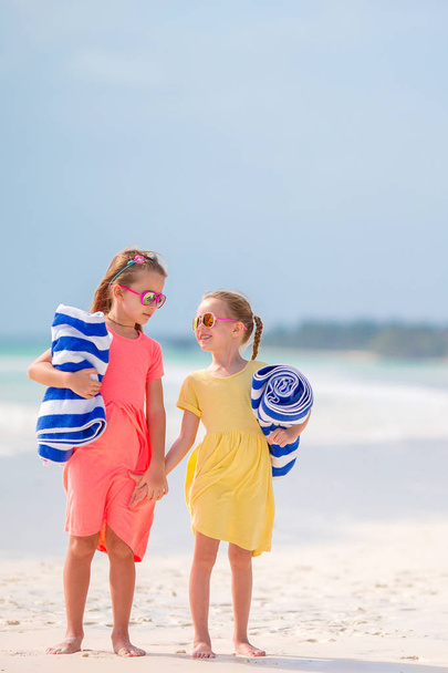 Petites filles avec serviettes prêtes à nager à la mer sur la plage tropicale
 - Photo, image