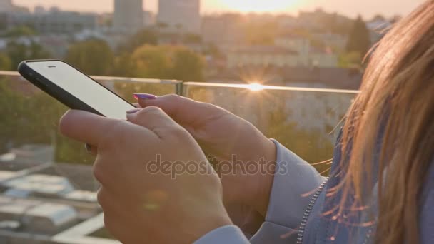 Μια νεαρή κοπέλα που χρησιμοποιούν ένα Smartphone σε εξωτερικούς χώρους - Πλάνα, βίντεο
