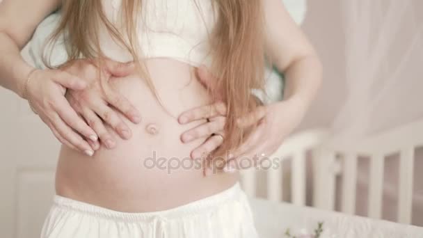 A pregnant woman and her husband in home hugging belly - Filmmaterial, Video