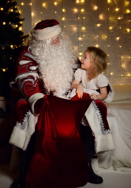Santa Claus with happy little cute children boy and girl near Christmas tree - Foto, Imagen