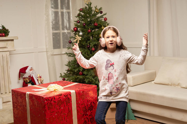Child is surprised by big red gift for  new year - Fotografie, Obrázek