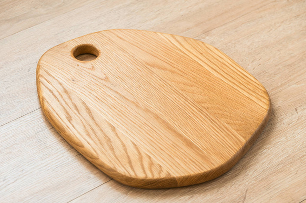 Placa de corte de madeira no fundo de madeira com espaço de cópia
 - Foto, Imagem