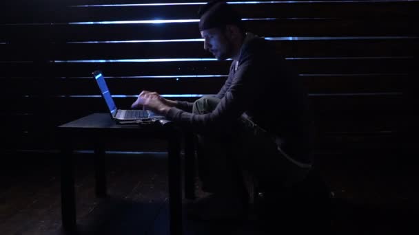 comic funny hacker commits a cyber attack with a laptop and a gun in his hands - Metraje, vídeo
