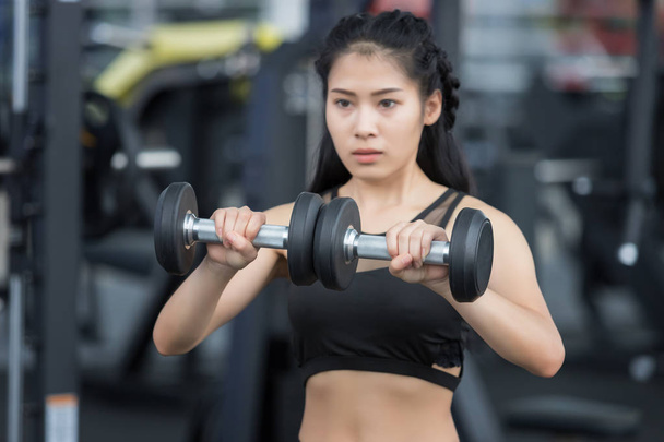Closeup of a young fitness asian woman workout at sport club. - Foto, imagen