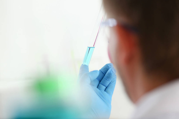 A male chemist holds test tube of glass - Foto, Bild