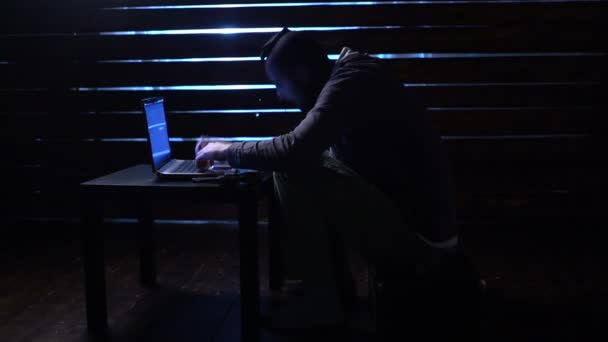 comic funny hacker commits a cyber attack with a laptop and a gun in his hands - Metraje, vídeo