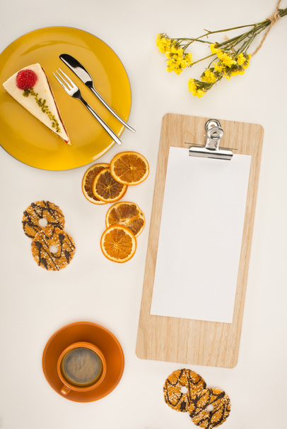 sheet of paper on clipboard and dessert - Zdjęcie, obraz