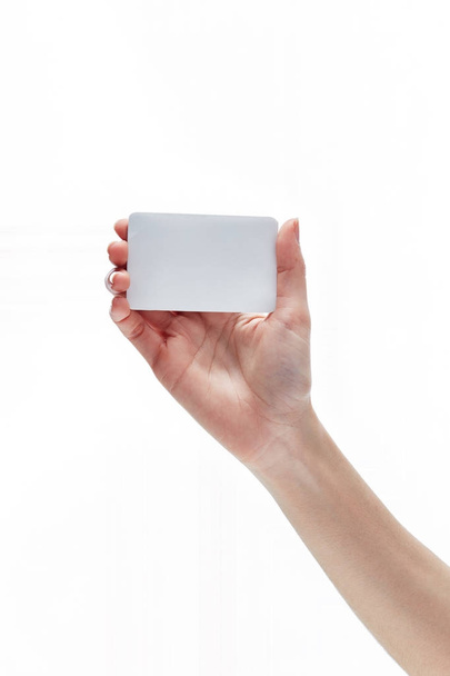 Female hand holding card isolated on white - Фото, изображение