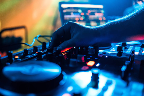 ruka přehrávače DJ posouvá ovládání hlasitosti a míchání hudby na míchačce - Fotografie, Obrázek