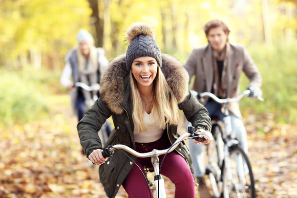 Group of friends on bikes in forest during fall time - Photo, Image
