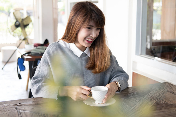 femme assise dans un café avec cappuccino chaud café sur table en bois durin
 - Photo, image