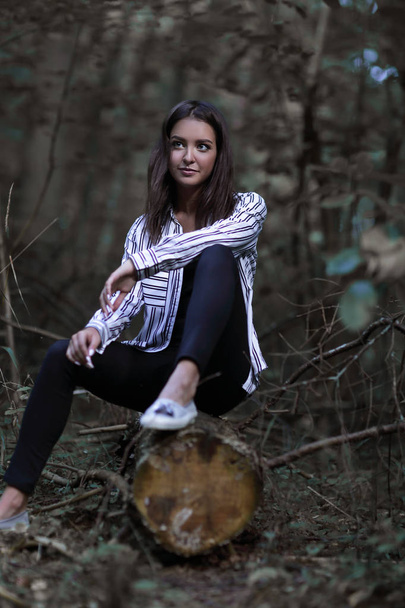 beautiful young woman sitting on a log - Foto, Bild