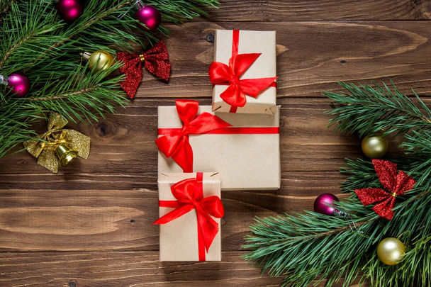 Agradável exposição de presentes de Natal com ouropel de pinheiros no meio do fundo de madeira
 - Foto, Imagem