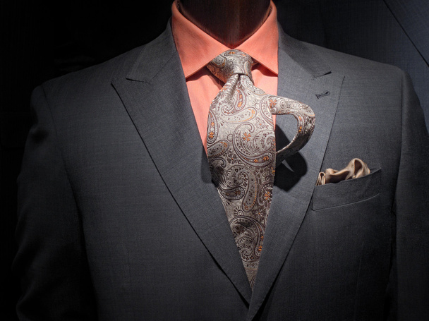 Giacca grigio scuro con camicia arancione, cravatta fantasia e fazzoletti
 - Foto, immagini