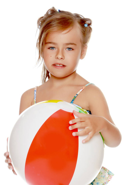 Little girl in a swimsuit with a ball - Fotó, kép