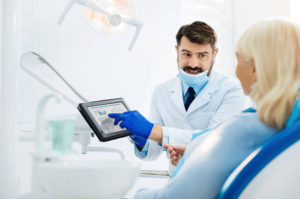 Smiling dentist using a tablet - Фото, зображення