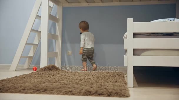 A little boy plays with toys and runs around the camera at home. - Filmati, video