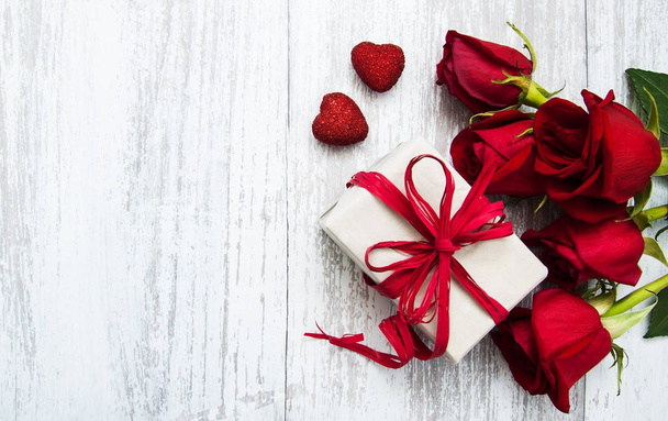 Kırmızı güller ve hediye kutusu - Fotoğraf, Görsel