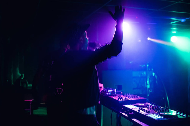 Ведущий ди-джей машет руками и кричит в микрофон в ночном клубе на вечеринке размыто и движение
 - Фото, изображение