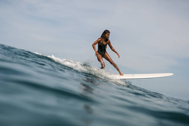 female surfer on surf board - Фото, зображення