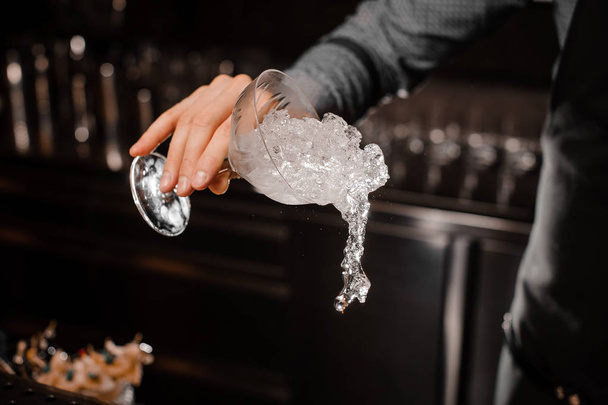 Bartender hand pouring a cocktail glass with ice - Photo, Image