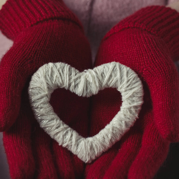 Tyttö punaisissa hanskoissa pitelee sydäntä
 - Valokuva, kuva