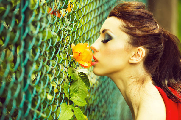 pretty woman smelling red poppy - Foto, afbeelding