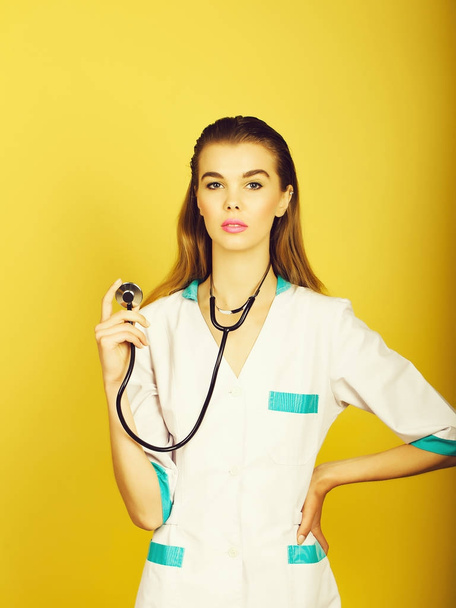 Cute woman doctor standing with stethoscope in hand - Foto, Imagen