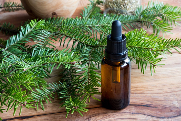 A bottle of fir essential oil with fir branches - Photo, Image