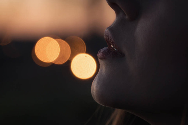 Женские губы крупным планом на фоне городских огней
 - Фото, изображение