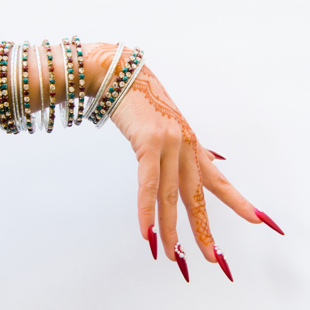 unhas decoradas com brilhante e mão com tatuagens de henna
 - Foto, Imagem