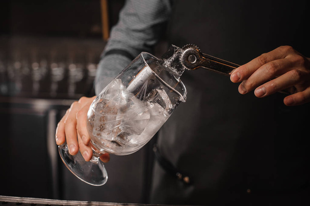 Bartender putting ice cubes into the cocktail glass - Φωτογραφία, εικόνα
