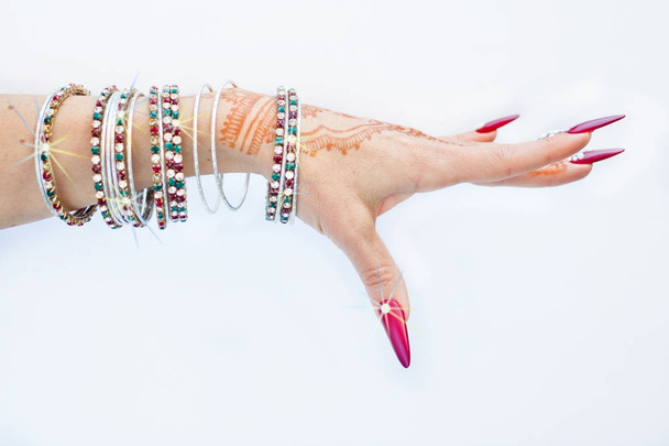 uñas decoradas con brillantes y mano con tatuajes de henna
 - Foto, Imagen