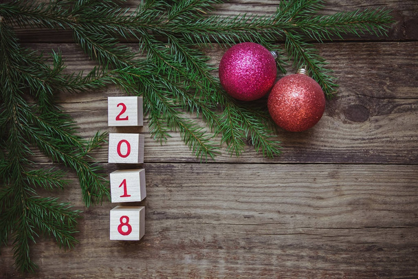 Imagen de Navidad: Año Nuevo 2018 se compone de cubos con ramas de abeto y pelotas de juguete
 - Foto, imagen