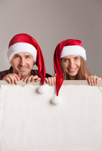 Couple in Santa hats with banner - Φωτογραφία, εικόνα