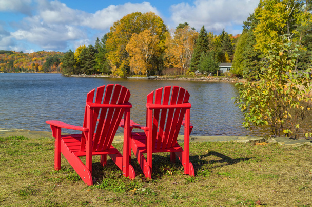 Red Adirondack Stoelen op een Lake Shore - Foto, afbeelding
