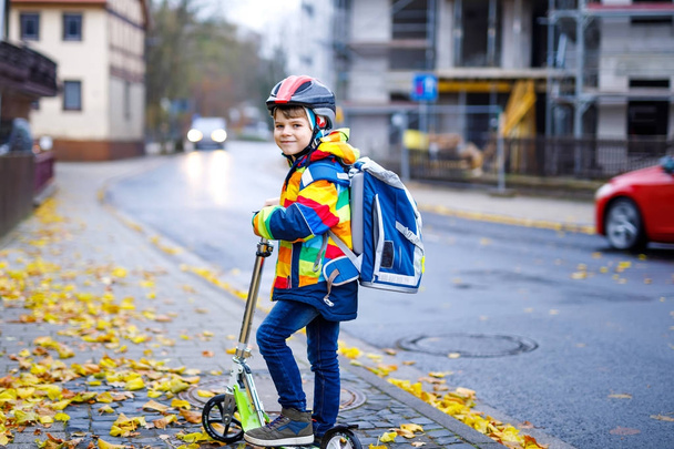 Cute little kid boy riding on scooter on way to school - Photo, Image