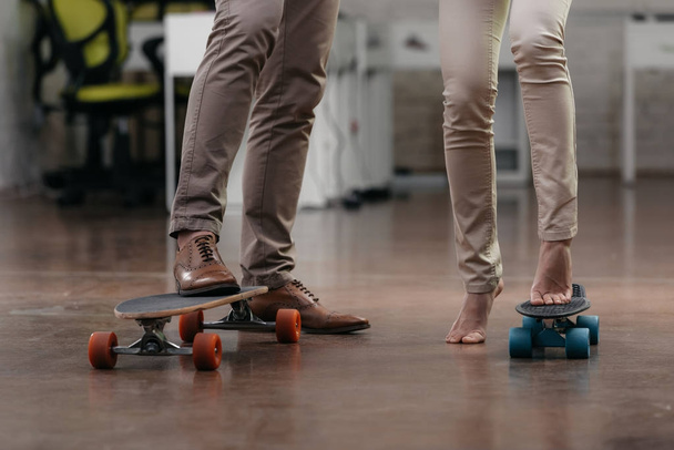 cropped view of businesspeople have fun with skateboards in office - Photo, image