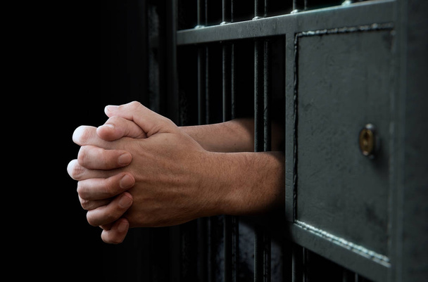Puerta y manos de celda de la cárcel
 - Foto, imagen