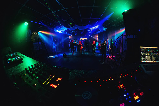 night club with dancing people on dance floor, revelers at a party and music Board of the DJ - Photo, Image