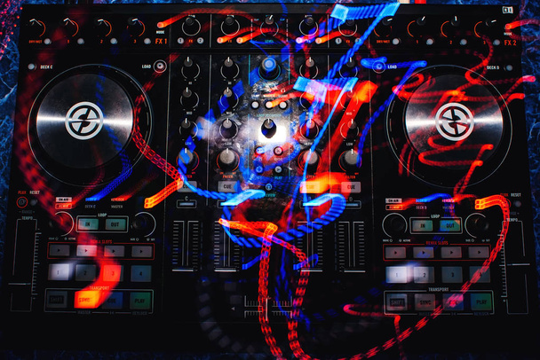 mezclador de música profesional DJ con controladores y botones con rastros de colores de efectos de luz
 - Foto, Imagen
