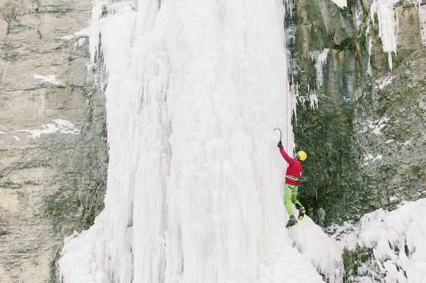 Ice climbing the North Caucasus, man climbing frozen waterfall. - Фото, изображение