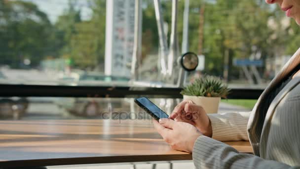 Una joven usando un Smartphone en el Café
 - Imágenes, Vídeo