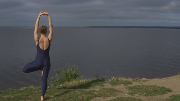 Йога-женщина в спортивной позе против озера
 - Кадры, видео