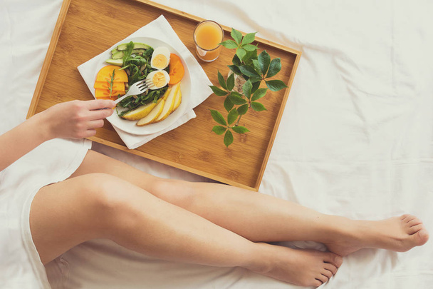 Healthy eating concept. Woman having breakfast in bed. Top view. - 写真・画像